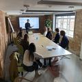 A-Level students sit around a boardroom table while a researcher speaks