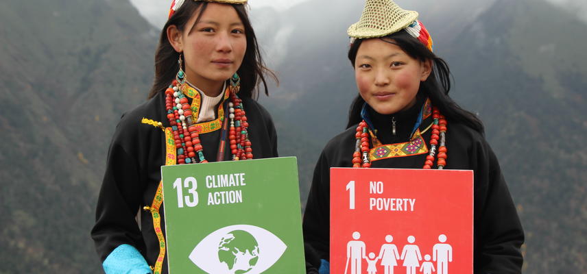 Two people holding signs which read '13 Climate Action' and '1 No Poverty'. Photo: UNDP Bhutan
