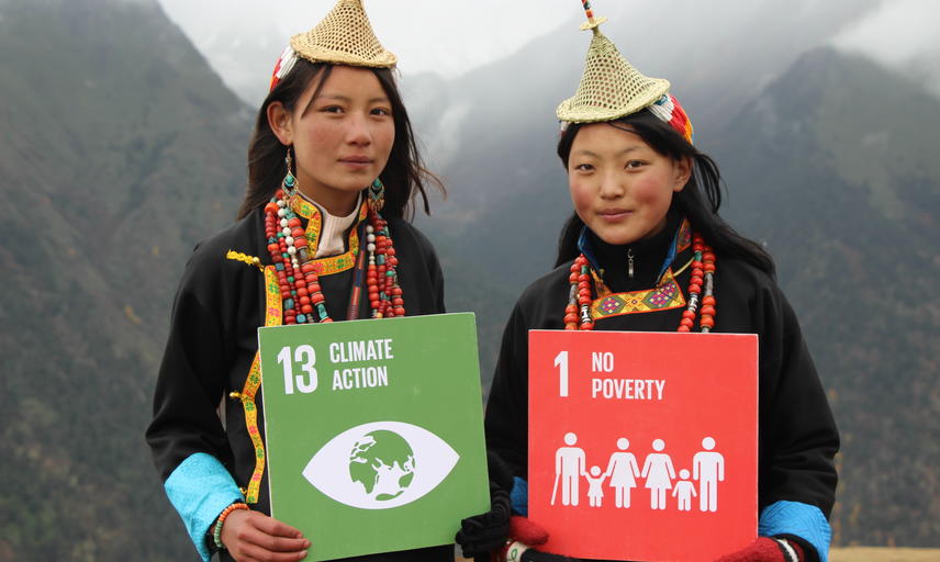Two people holding signs which read '13 Climate Action' and '1 No Poverty'. Photo: UNDP Bhutan