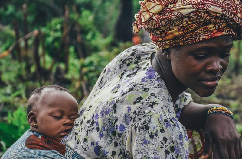 Image of a woman carrying a baby on her back