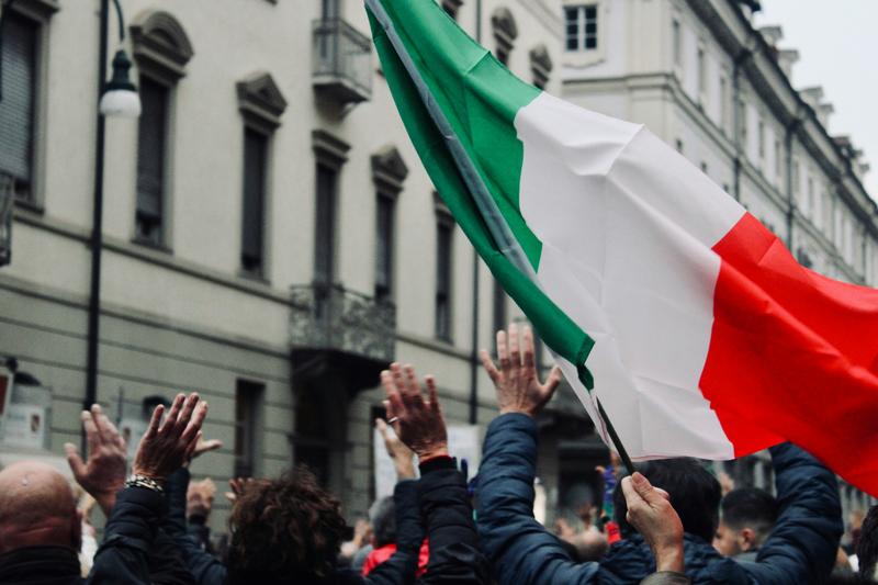 A crowd hold up a Italian flag in Torino, Italy