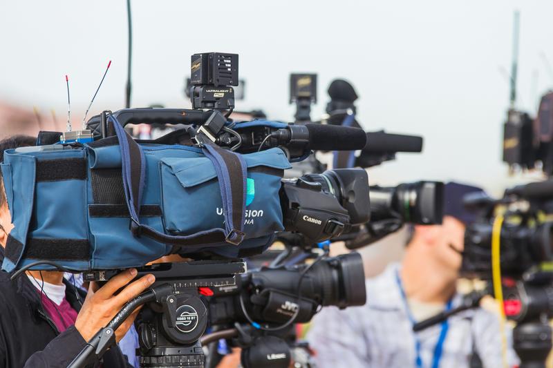 Image of media cameras capturing news coverage
