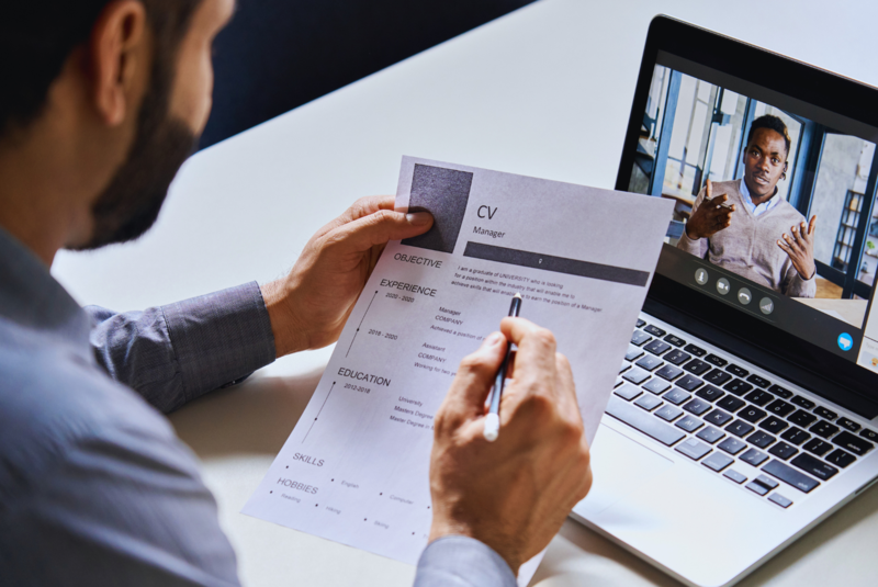Man reviews a CV while talking online with a candidate 
