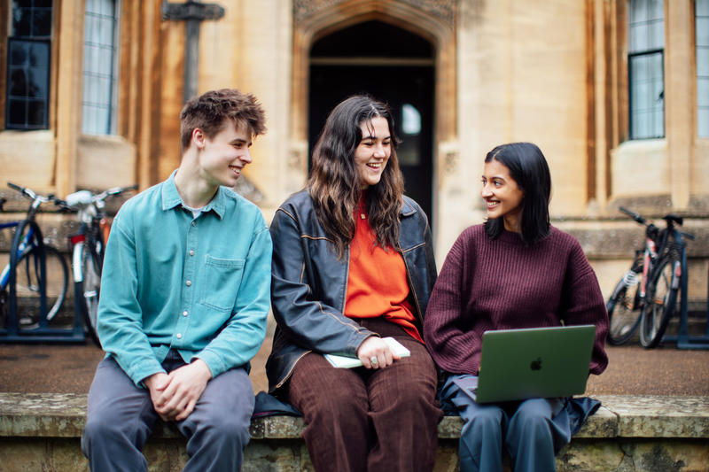 Image of three students sitting outside