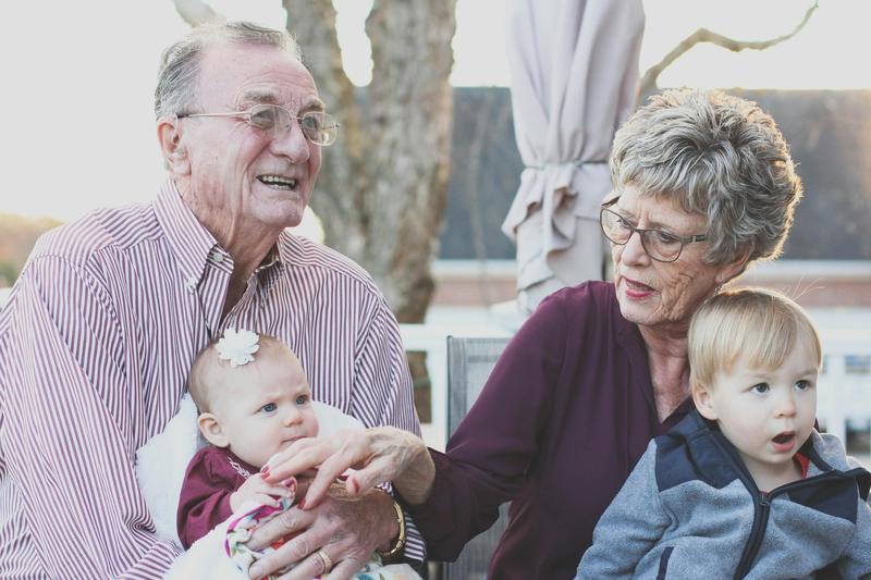 Image of an elderly couple sitting with their two young grandchildren 