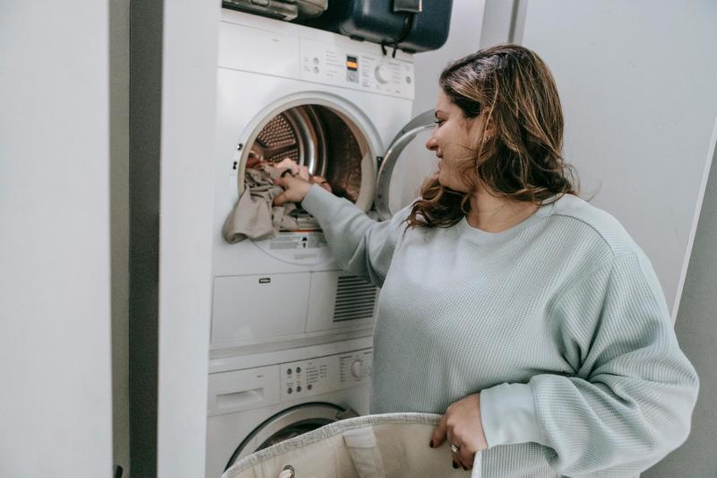 Image of a woman loading a washing machine