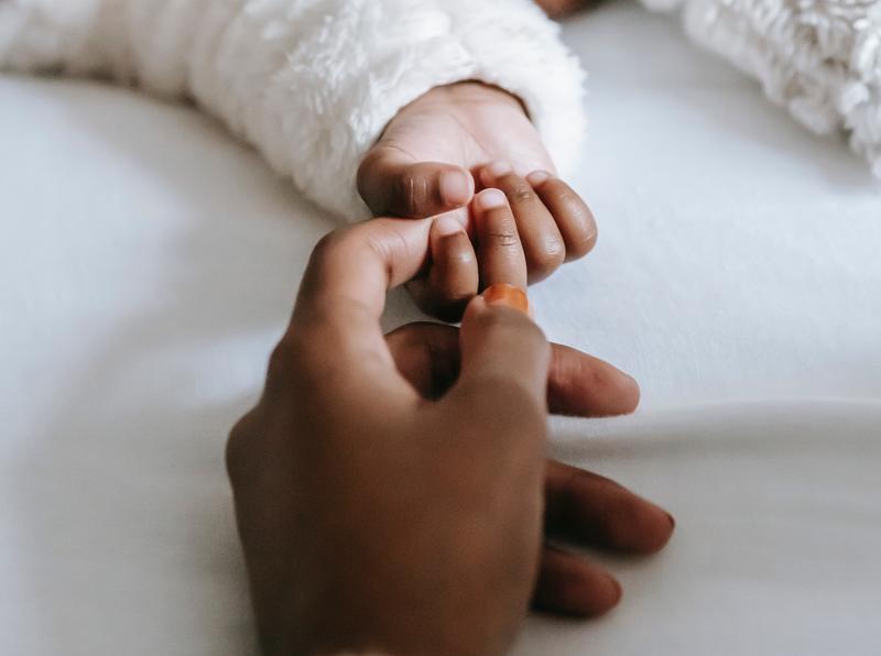 Close up of mother holding her baby's hand