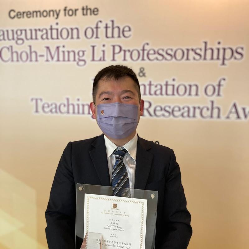 Yiu-tung Suen holds an award and certificate 