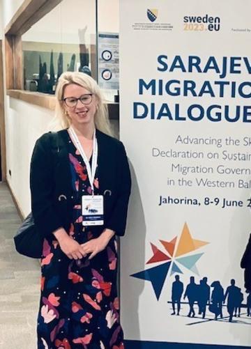 Image of Dora Meredith standing next to a conference poster