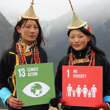 Two people holding signs which read '13 Climate Action' and '1 No Poverty'. Photo: UNDP Bhutan