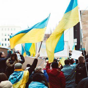 Image of people gathering on the street holding Ukrainian flags