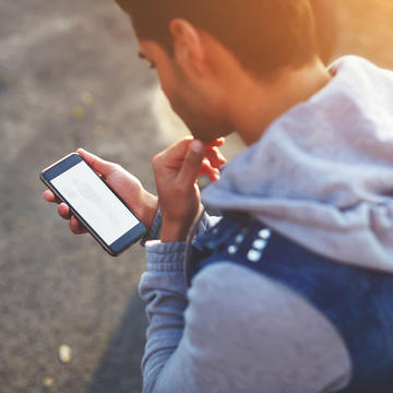 A teenager looking at a phone. Photocredit Shutterstock