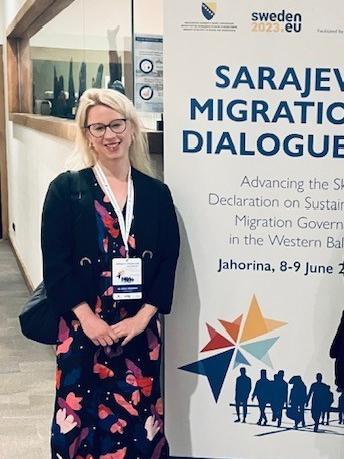 Image of Dora Meredith standing next to a conference poster