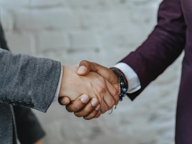 Two people shake hands
