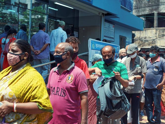 People waiting in long queues outside a Kolkata community health clinic, waiting for the covid-19 vaccine.