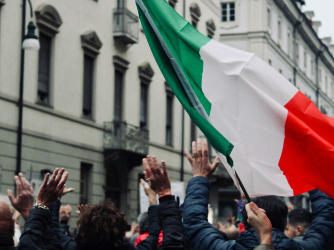 A crowd hold up a Italian flag in Torino, Italy