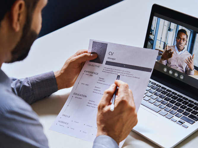 Man reviews a CV while talking online with a candidate 