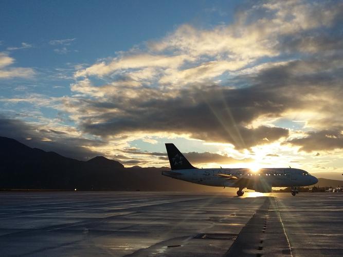 An image of a plane on a runway during sunset