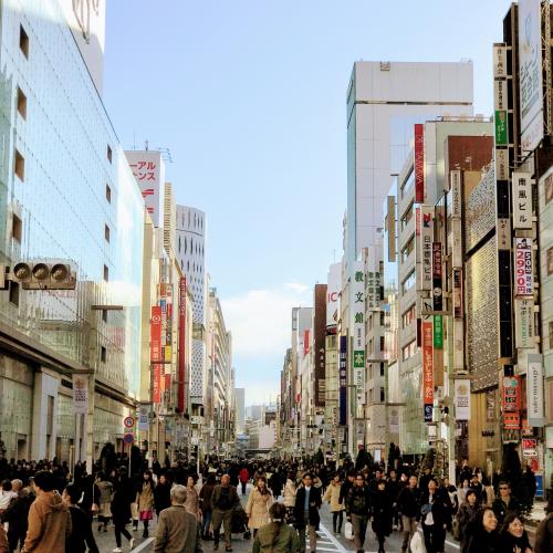 Crowds of people walk down a street in Tokyo