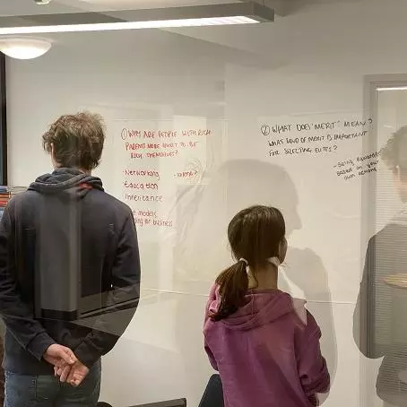 A-Level students looking at whiteboard