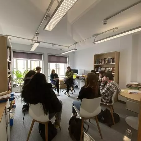 A-Level students sit in a circle while a researcher speaks