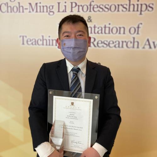 Yiu-tung Suen holds an award and certificate 