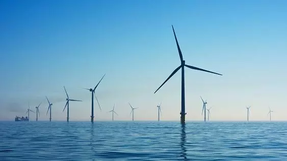 Wind farm at sea against a blue sky