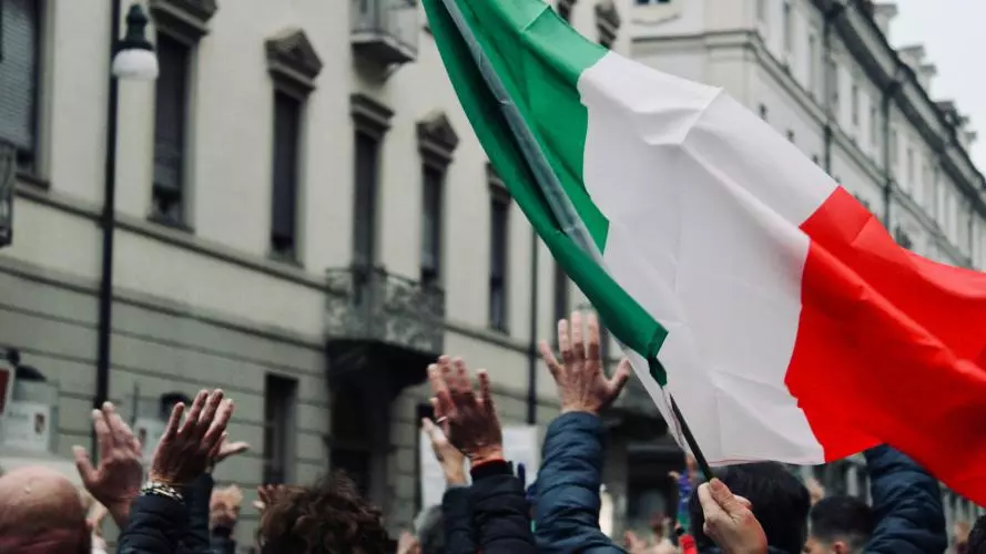 A crowd hold up a Italian flag in Torino, Italy