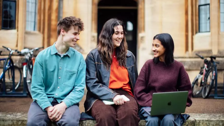Image of three students sitting outside