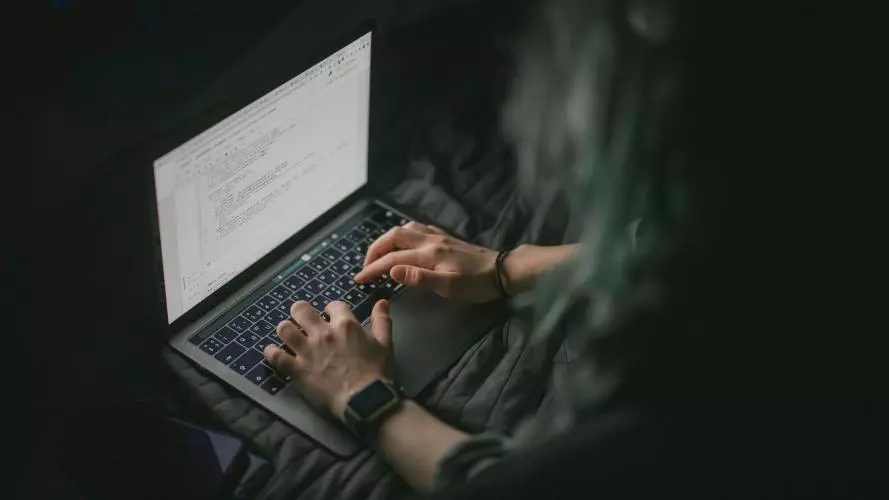 Image of individual typing on laptop