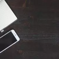 Lined notepad and pen next to iPhone