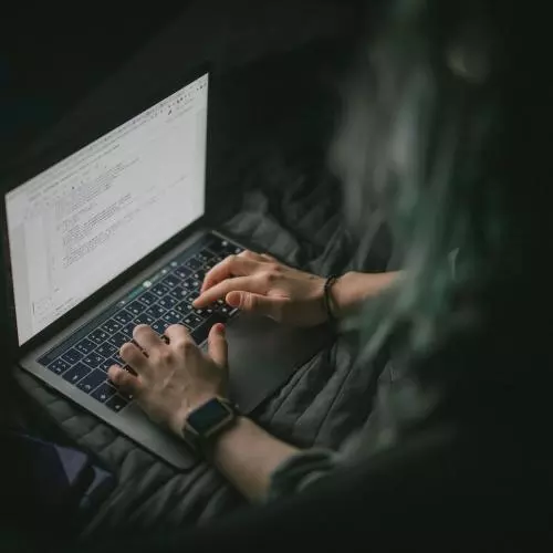 Image of individual typing on laptop