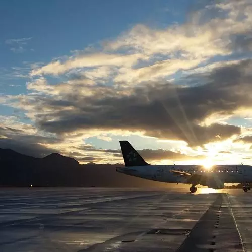 An image of a plane on a runway during sunset