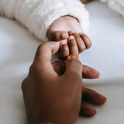 Close up of mother holding her baby's hand