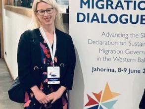 Image of Dora Meredith standing next to a conference poster