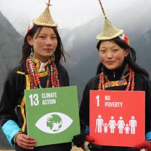 Two people holding signs which read '13 Climate Action' and '1 No Poverty'. Photo: UNDP Bhutan