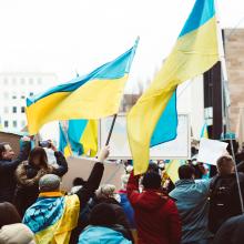 Image of people gathering on the street holding Ukrainian flags