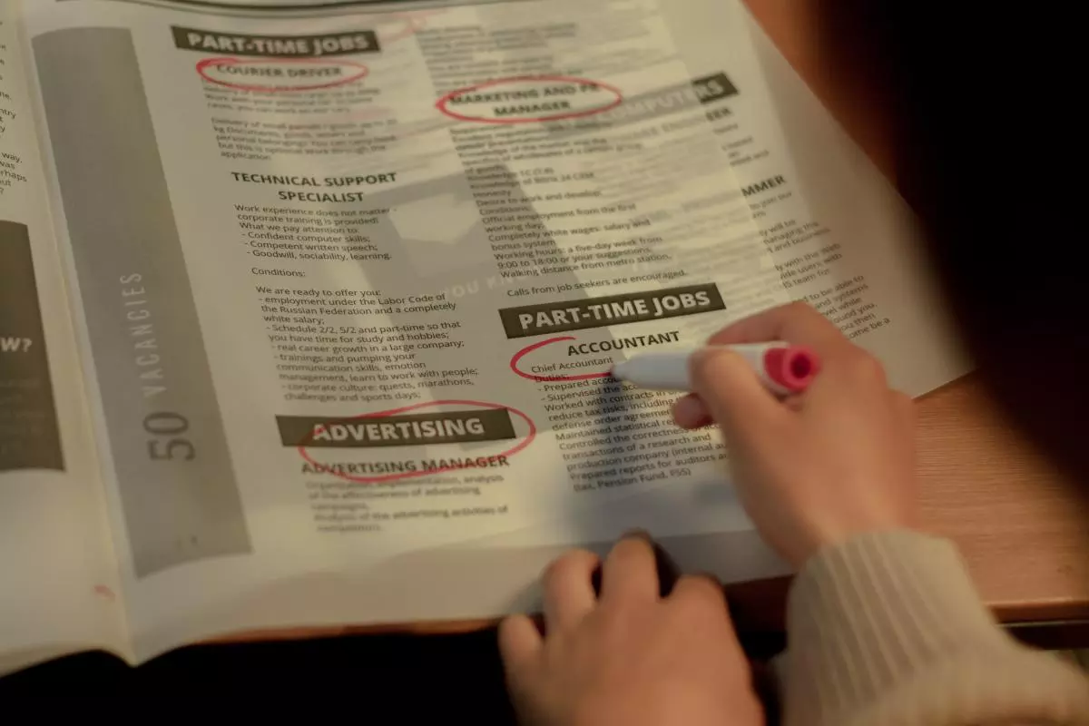 A person circling job ads in the newspaper