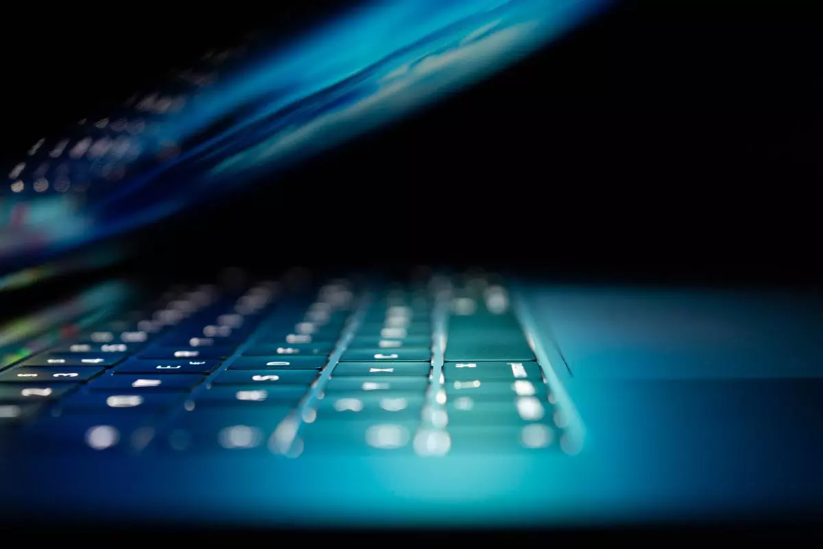 Image of a half-closed laptop in a darkened room